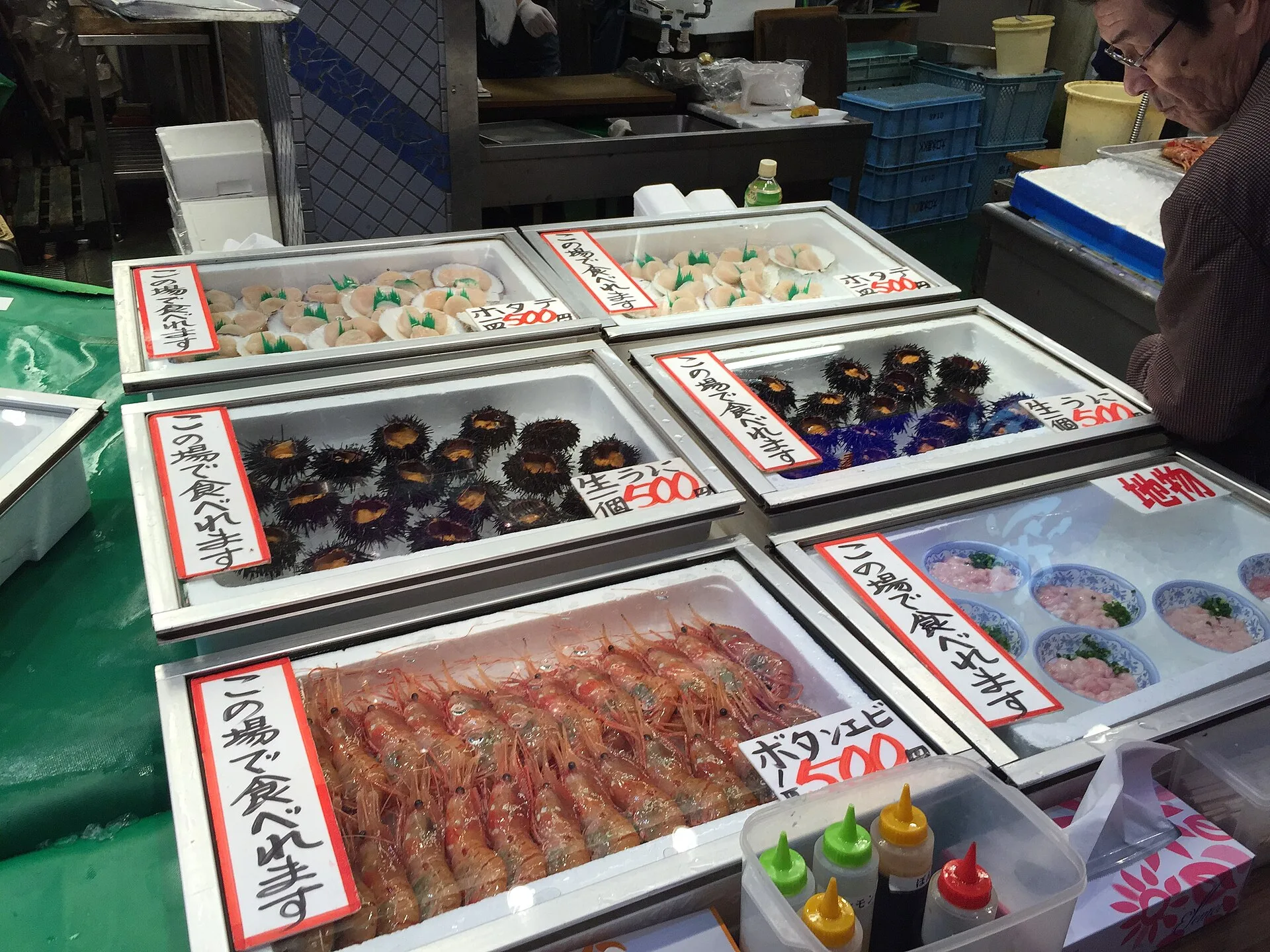 A handwritten shop sign at Omicho Market inviting customers to eat on the spot